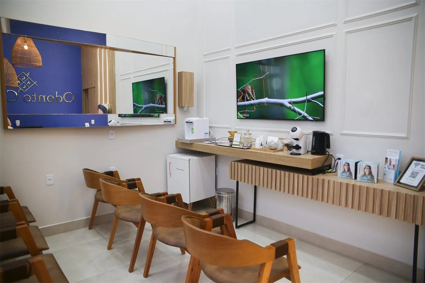 Recepção da Odonto Calaça com cadeiras e painel azul